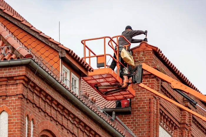 Homeowner inspecting roof and gutters for storm damage in Houston